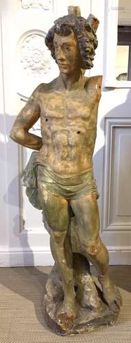 SAINT SEBASTIEN en stuc polychrome. Debout, appuyé sur sa jambe droite, il a les mains attachées à un arbre derrière son dos. Italie, XVIe siècle Hauteur : 116 cm (quelques accidents et manques) Haut : 116 cm  Expert : Cabinet Fligny