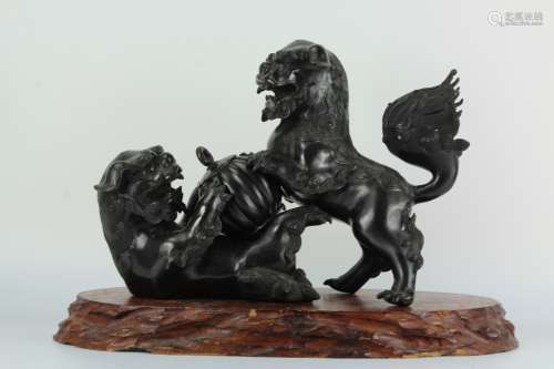 A pair of Japanese bronze figure of lions playing with ball on wooden base