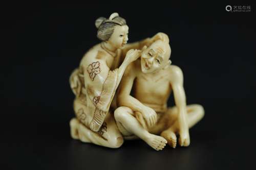 Vintage Netsuke carving of a woman cleaning a man's ear