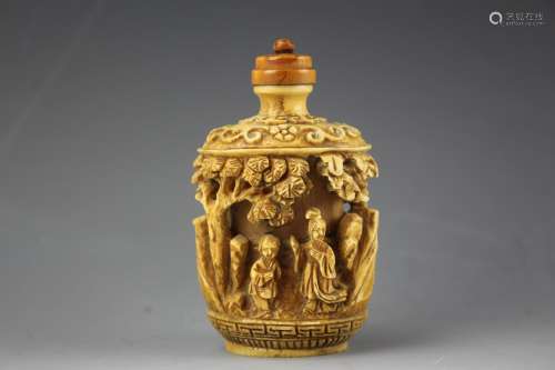 Chinese snuff bottle with sandlewood stopper. Bone carved frieze of figures in a garden. Qianlong mark
