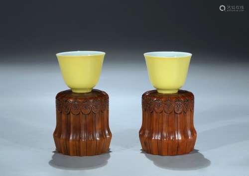 A pair of lemon yellow glazed cups with stands