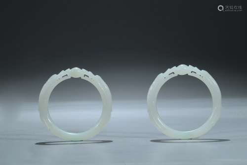 A pair of white jade 'dragon' bangles