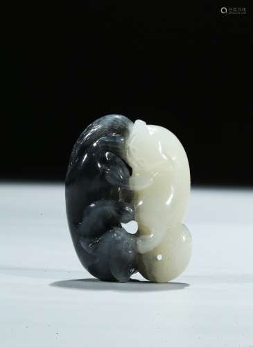 A white and black jade carving of two cats