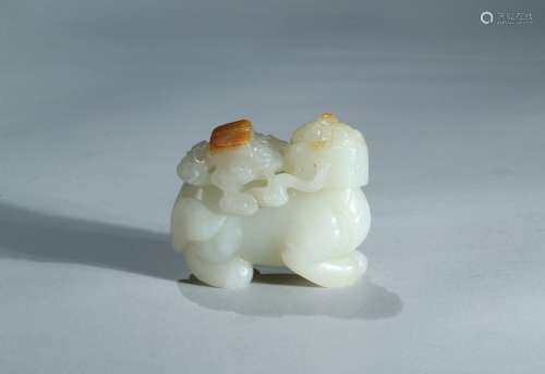 A white jade with russet skin carved mythical beast