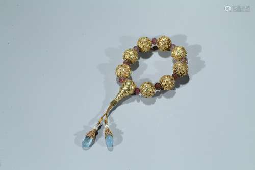 A gold cast 'eight auspicious motif' and tourmaline rosary bracelet