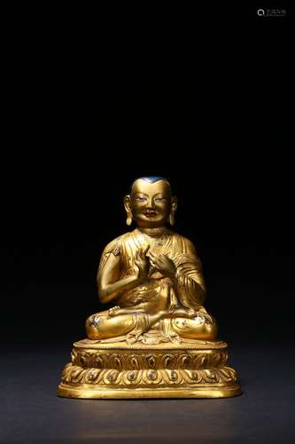 A gilt-bronze figure of Guru