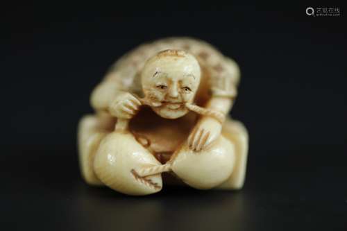 Japanese Netsuke carving of a man on top of a crab