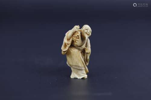 A Carved Netsuke of An Elder Man Holding Grapes Signed