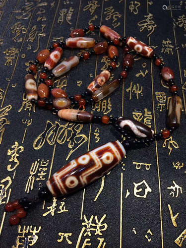 AN OLD MINE NINE-EYE DZI BEAD RED MARBLE NECKLACE