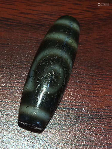 AN OLD ORE CHARGE TWO-EYE DZI BEAD