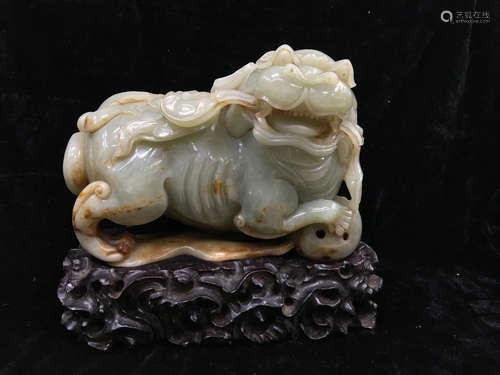 Chinese carved jade lion on wood stand.