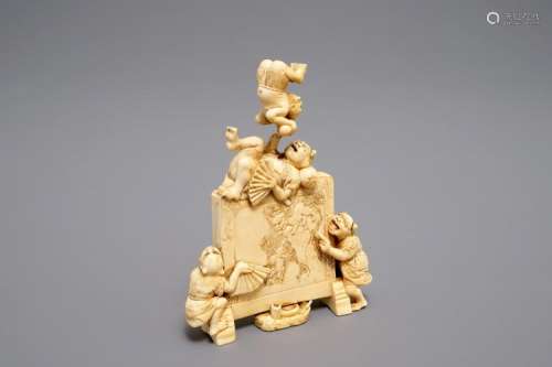 A JAPANESE CARVED IVORY OKIMONO WITH ONI AROUND A SCREEN, SIGNED, MEIJI, 19TH C.