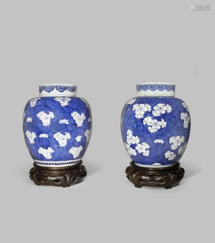 A NEAR PAIR OF CHINESE BLUE AND WHITE 'PRUNUS' JARS AND COVERS