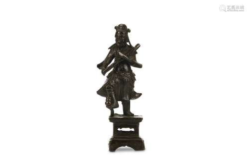 A CHINESE STANDING BRONZE FIGURE. Ming Dynasty. Standing on a rectangular plinth with one foot