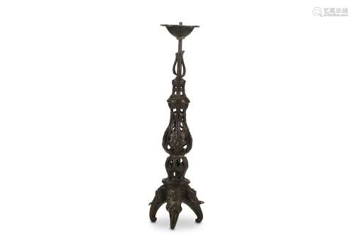 A BRONZE CANDLE STICK. Ming Dynasty. Supported on tripod elephant head feet, supporting a slender