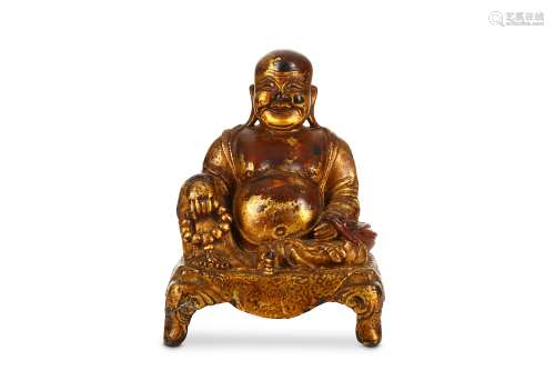 A CHINESE GILT-LACQUER BRONZE FIGURE OF BUDDHA. Ming Dynasty. The smiling, corpulent figure is