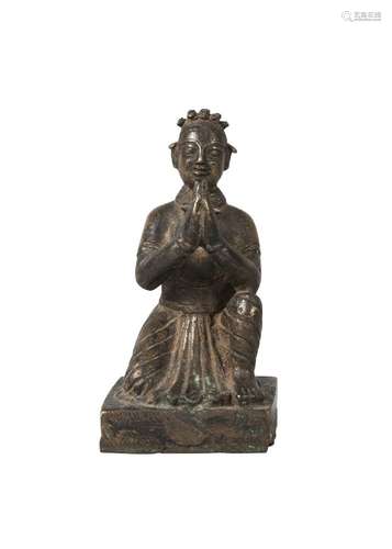 A Nepalese bronze kneeling figure, 19th century, with hands clasped, on square base, 10cm high