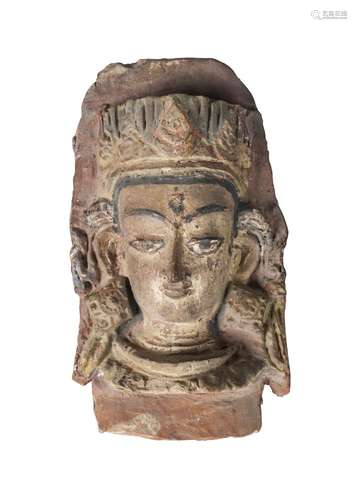 A Tibetan terracotta head, 19th century, modelled as the head of Shiva, later painted, 23cm high