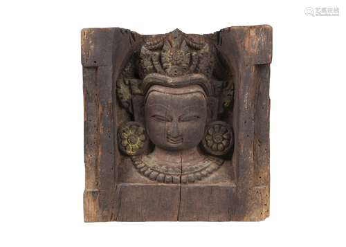 A Nepalese carved wood relief, 19th century, depicting a female deity wearing elaborate headdress,