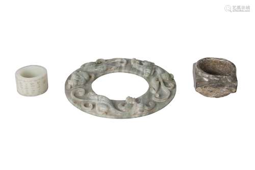 Three Chinese green hardstone carvings, 20th century, comprising a large ring incised with peony