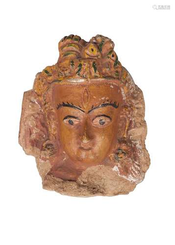 A Tibetan terracotta head of Shiva, 19th century, with later painted features, 19cm high