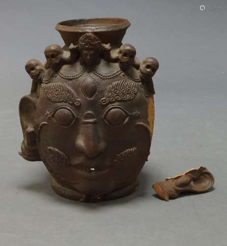 A large Nepalese terracotta jar, 20th century, formed as a Bhairava mask adorned with skulls, 58cm