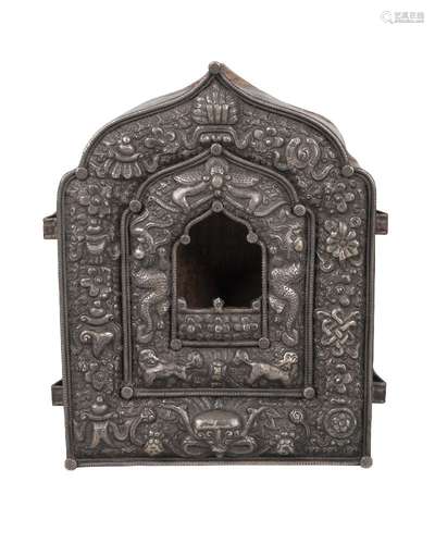 A Tibetan silver and copper backed gau, late 19th century, repousse decorated with Buddhist emblems,