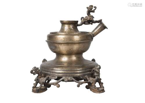 A Nepalese brass lamp base, 19th century, surmounted with a winged dragon and cast with four