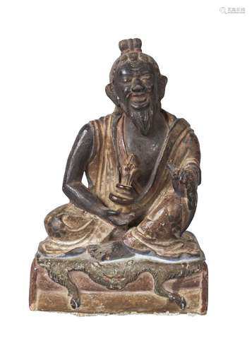 A Tibetan painted terracotta figure of Mahasiddha, early 19th century, depicted seated on a