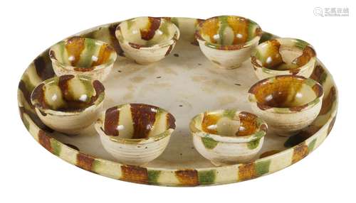 A Chinese pottery sancai glazed tray and eight cups, Tang dynasty style, the circular tray raised on