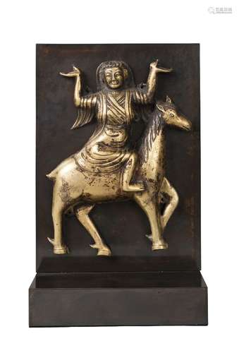 A Tibetan gilt copper repousse plaque, 17th/18th century, modelled with a tantric divinity astride a