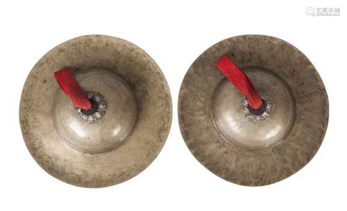 A pair of Tibetan beaten brass cymbals, 19th century, with repousse silver fittings, 31.5cm diameter