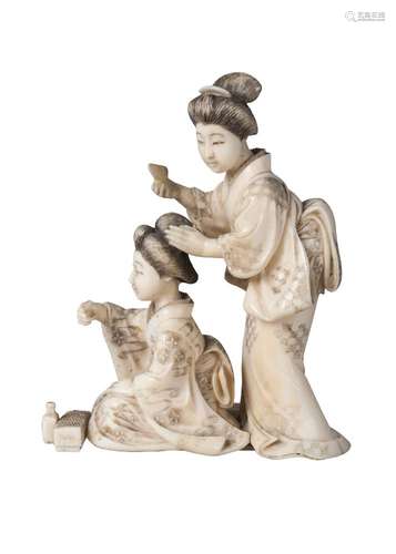 A Japanese ivory okimono of two ladies, late 19th century, carved as a geisha attending to the