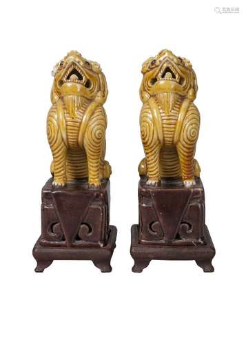 A pair of Chinese porcelain Buddhist lions, 18th century, both modelled seated on brown-glazed