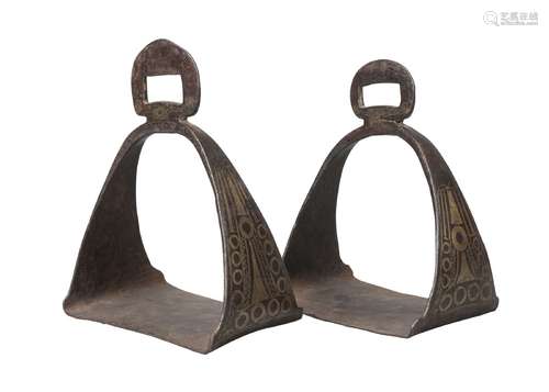 A pair of Tibetan damascened iron stirrups, 19th century, decorated to the tapering sides with