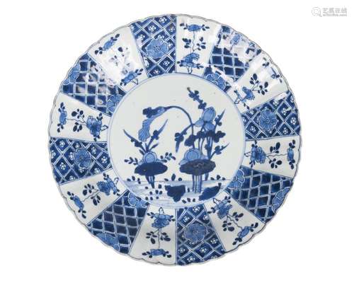 A Chinese porcelain plate, Kangxi, late 17th century, painted in underglaze blue with flowering