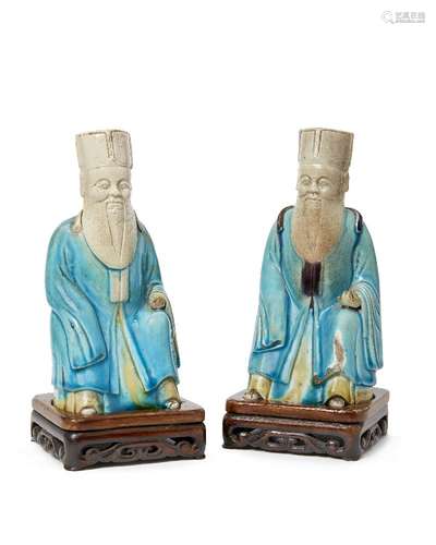 A pair of Chinese porcelain officials, 18th century, modelled seated, wearing turquoise robe,