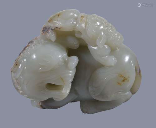 A Chinese celadon and russet jade 'lion and cub' carving, with the head turned sharply to the left