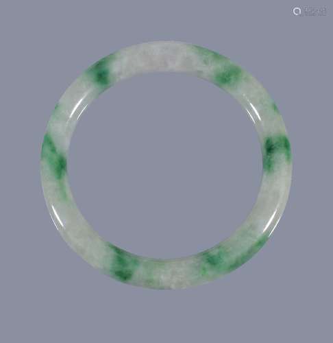 A Chinese jadeite bangle, the cylindrical jadeite band of pale green and cloudy white tone, suffused