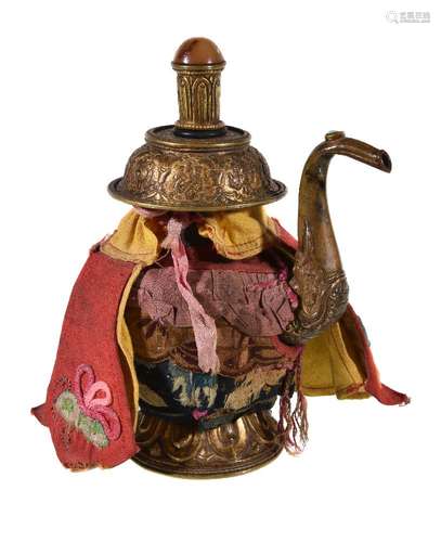 A Tibetan gilt brass ewer, 19th century, on lotus rim foot, with scrolling spout issuing from a