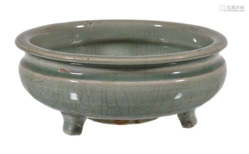 A Chinese celadon tripod censer, Ming Dynasty, with crazed pale-green glaze and raised on tapering