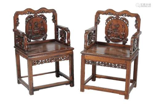 A pair of Chinese hardwood chairs, late Qing Dynasty, the shaped rectangular backs centred