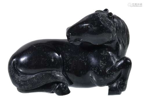 A Chinese carved stone or jade model of a horse, the reclining animal well carved with its head