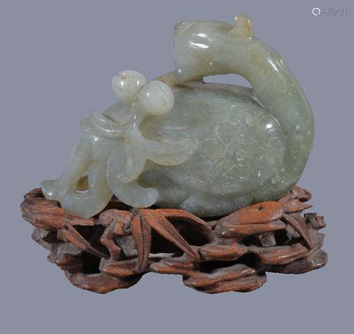 A Chinese jade or jadeite figure of a Phoenix, holding a peach branch, the jadeite 10.5cm wide x 7.