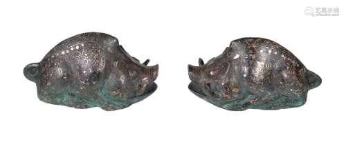 A pair of Chinese archaistic silver inlaid bronze boars, with legs facing forward and showing the