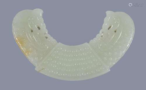 A Chinese archaistic white and russet jade pendant, Huang, the arc-shaped pendant carved in low