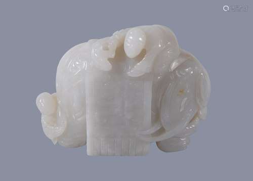 A Chinese white jade carving of and elephant, with brown inclusion to one side, with one figure on