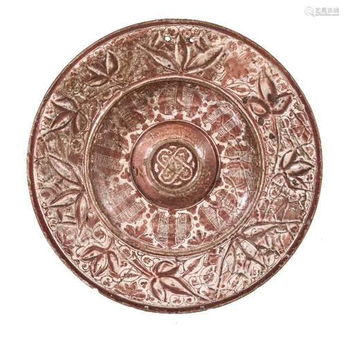 A Hispano-Moresque tin glazed pottery copper lustre charger, 16th century, with central boss and