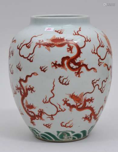 Porcelain vase. China. 19th century. Oviform shape. Decoration of iron red dragon above a green wave ground. 7