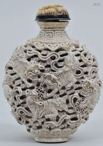 Snuff bottle. 19th century. White porcelain carved with foo dogs, brocade balls and clouds. 2-5/8